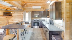 A compact kitchen with wooden walls, a central island, and modern appliances. - 5 Mi to Lake Barkley: Secluded Retreat in Kuttawa (Kuttawa)