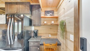 A compact kitchen with a stainless steel refrigerator, wooden cabinets, a coffee maker, and a small wooden table. - 5 Mi to Lake Barkley: Secluded Retreat in Kuttawa (Kuttawa)