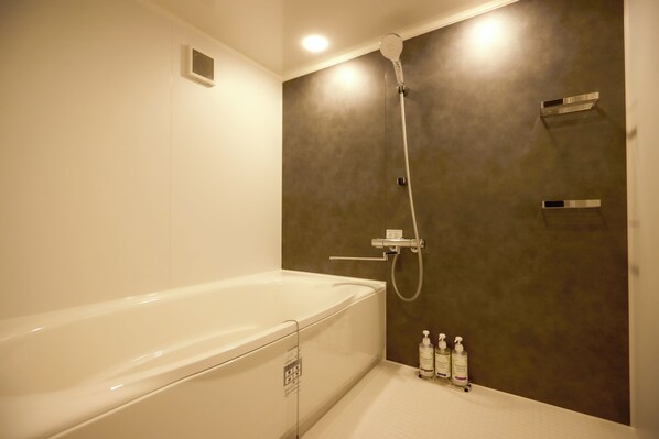 Une salle de bain moderne équipée d’une baignoire, d’une douche et d’un meuble-lavabo avec des articles de toilette.