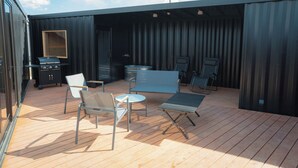 An outdoor patio with a grill, seating area, and a view of the sky. - No.12 Kashima Fan Zone (Kashima)