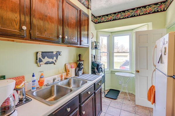 Kitchen features a sink, island with sink and countertop, and a refrigerator.