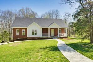 A two-story house with a brick exterior, white trim, and a covered front porch. - Hot Tub, Deck & Fire Pit: Chic Louisville Home! (Louisville)