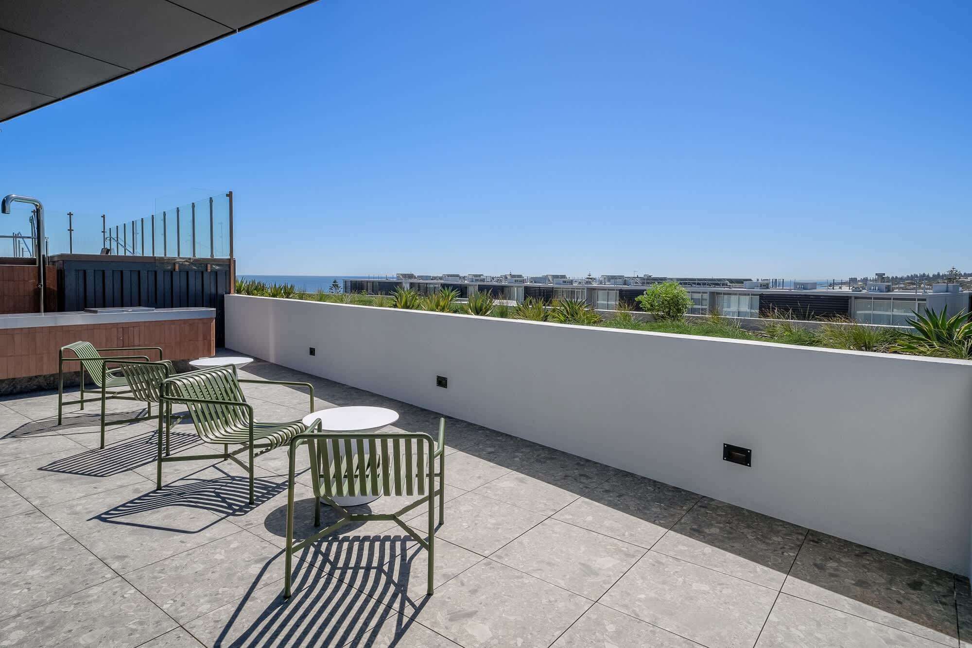 Eine Dachterrasse mit Sitzgelegenheiten im Freien und Blick auf die Stadtlandschaft.