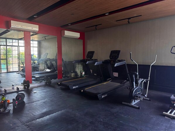 A gym with treadmills, a stationary bike, and weightlifting equipment.