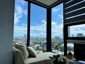 A modern living room with a large window offering a city view.