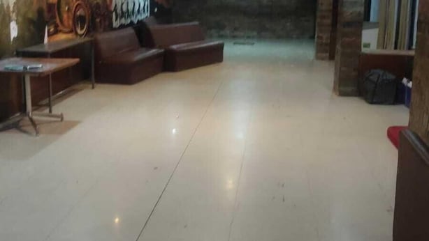 Eine großzügige, helle Lobby mit einer Sitzecke, einem Wandgemälde und einem Empfangstresen.