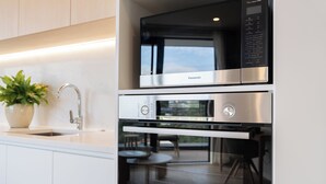 Uma cozinha moderna com micro-ondas e forno embutidos, uma pia e um vaso de planta.