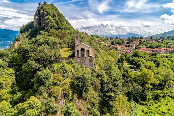 Perched atop a lush hill, a historic church offers a tranquil retreat amidst rolling hills and a quaint village.