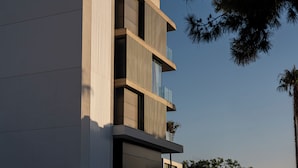 Een modern gebouw met een verticale uitstraling, voorzien van meerdere balkons en grote ramen.