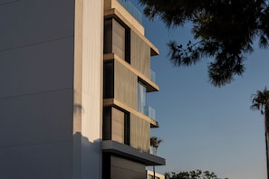 Un edificio moderno dal design verticale, con diversi balconi e ampie finestre.