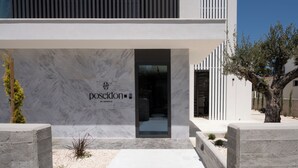 A modern building with a marble facade and a sign that reads 'posidon by deserve'.