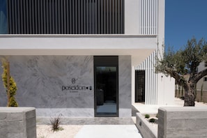 Un bâtiment moderne avec une façade en marbre et une enseigne sur laquelle on peut lire « posidon by deserve ».
