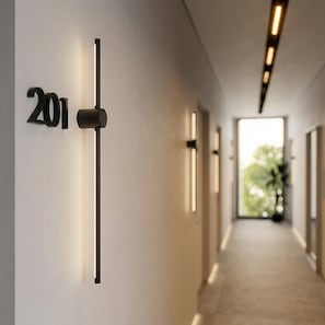 Un pasillo moderno con un cartel con el número '201', iluminación empotrada y vistas a una habitación luminosa con una planta.