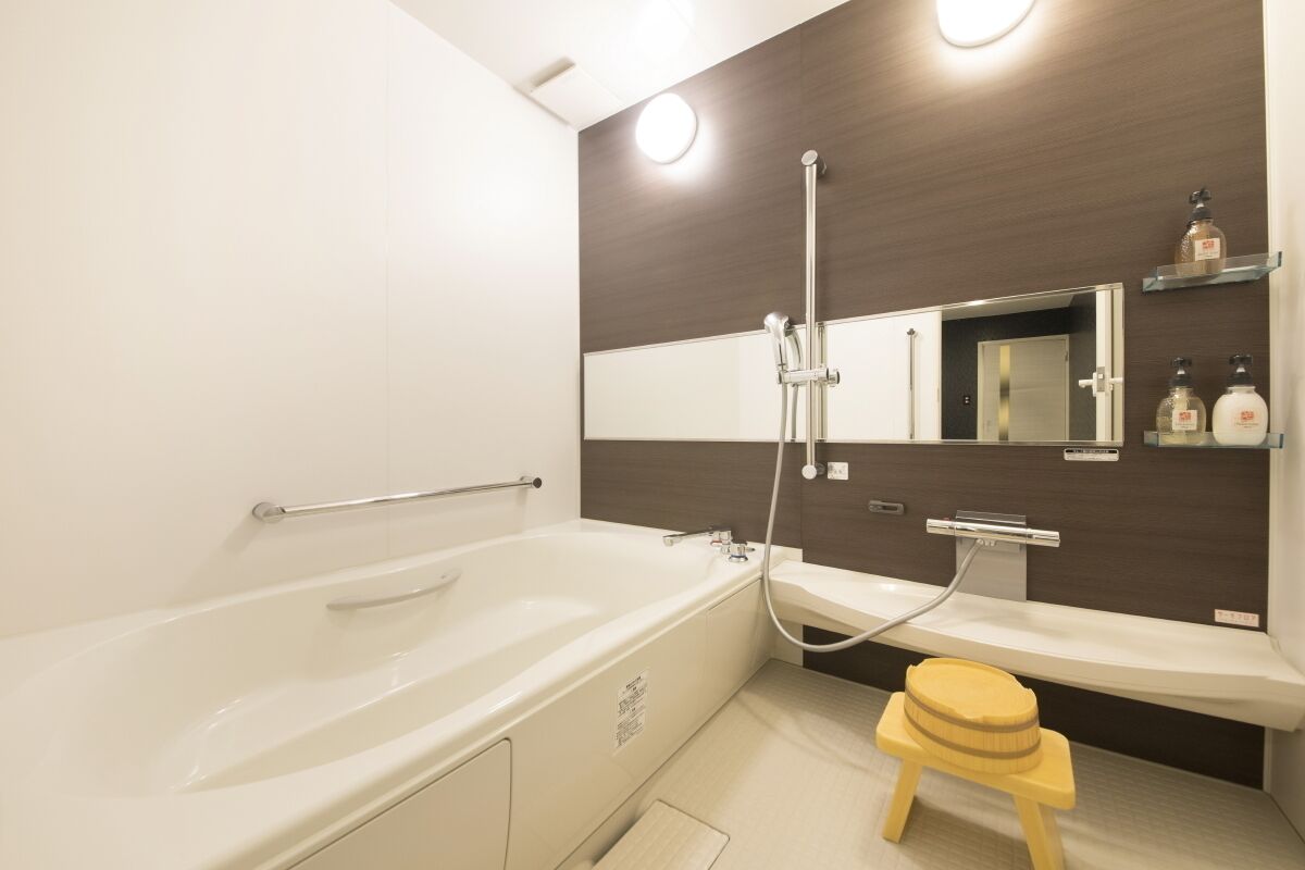 A modern bathroom with a bathtub, a shower, a toilet, and a vanity with a mirror.