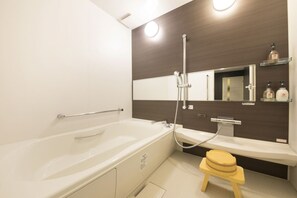 A modern bathroom with a bathtub, a shower, a toilet, and a vanity with a mirror. - Yutorelo Beppu (Beppu)