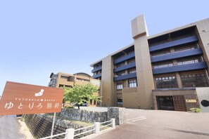 A multi-story building with a signboard in front. - Yutorelo Beppu (Beppu)