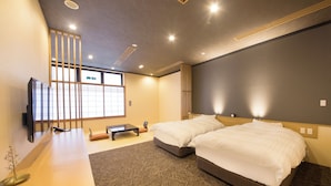Une chambre d’hôtel moderne, dotée d’un grand lit, d’un bureau et d’une télévision.