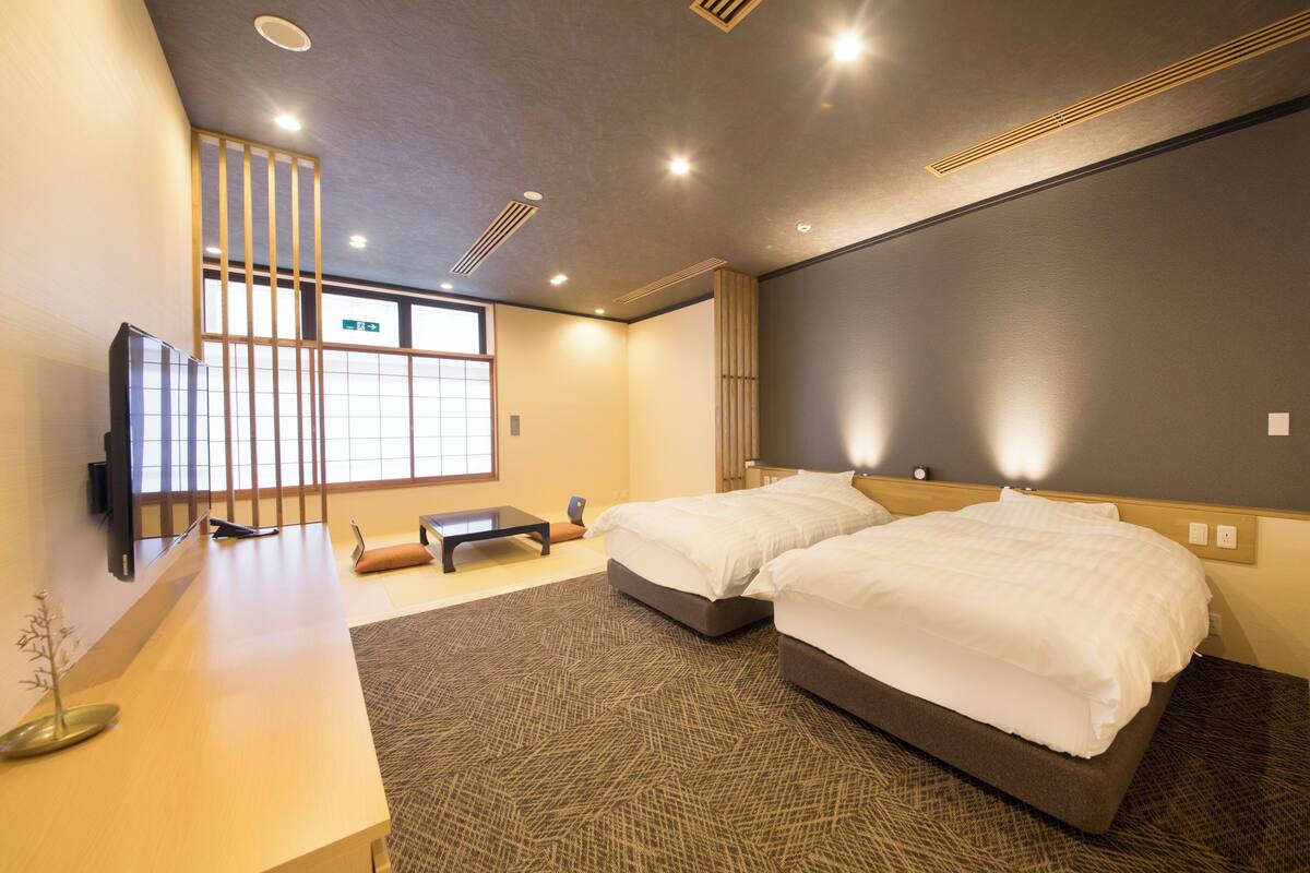 Une chambre d’hôtel moderne, dotée d’un grand lit, d’un bureau et d’une télévision.