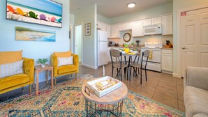 A living room with two yellow armchairs, a coffee table, and a patterned rug.