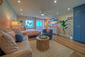 Una sala de estar con sofá, sillón, mesa de centro, televisor y alacenas.