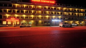 Ein mehrstöckiges Hotel mit einer auffälligen Neonreklame für Kailash International.