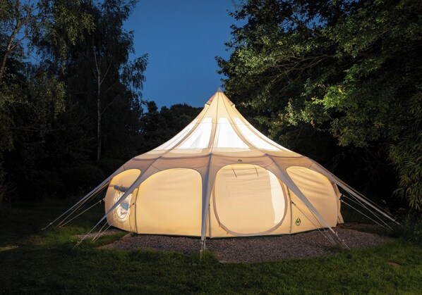 A large, dome-shaped tent with multiple entry points and a central pole, set in a grassy area surrounded by trees. - Tranquil Luxury Glamping Escape in Ross-on-wye 8 (Ross-on-Wye)