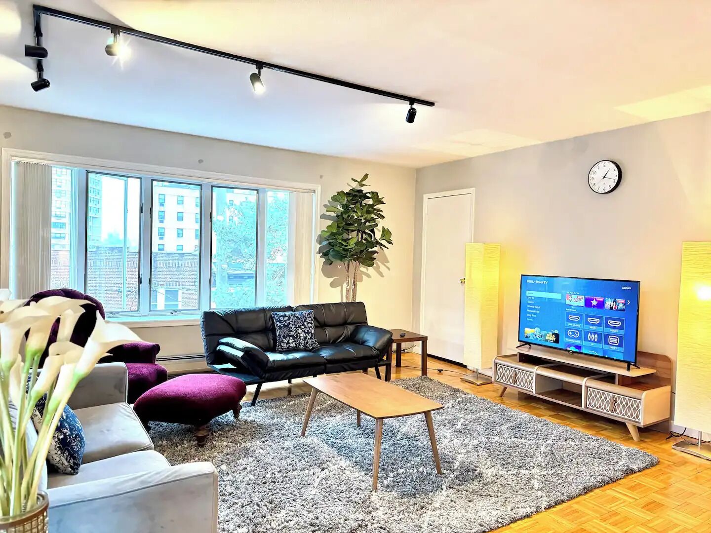 Una sala de estar moderna con sofá, mesa de centro y televisor.