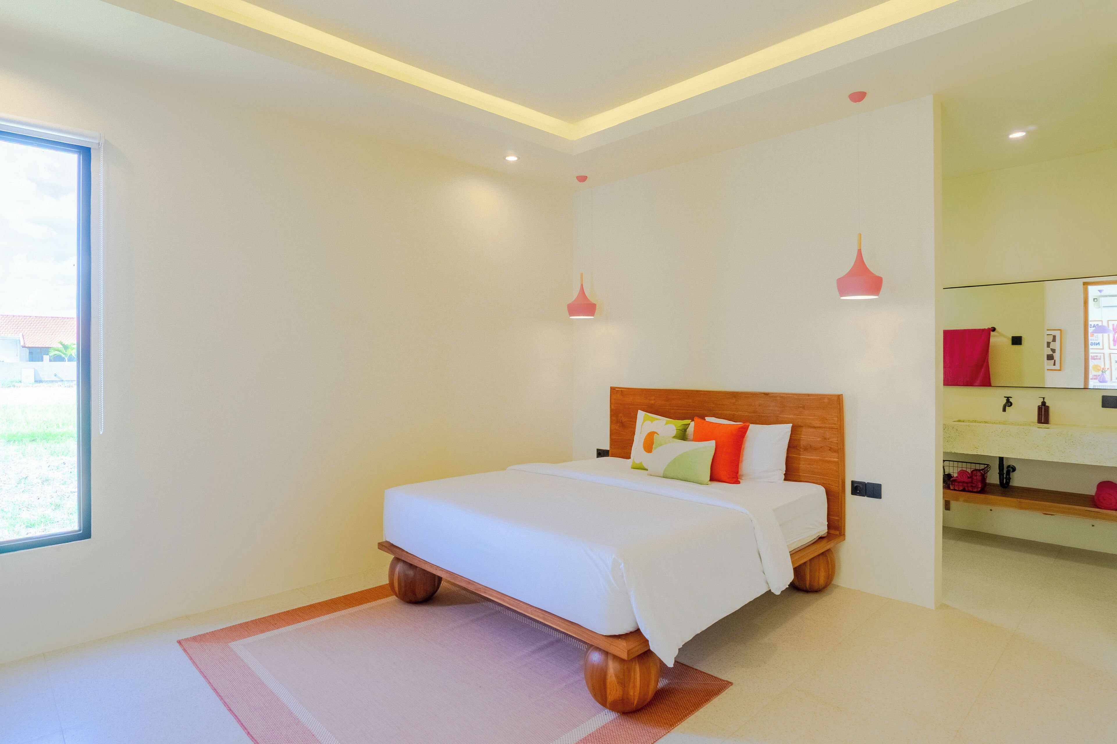 A modern bedroom with a wooden bed, a large window, and a bathroom with a sink and mirror.