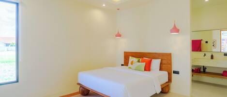 A modern bedroom with a wooden bed, a large window, and a bathroom with a sink and mirror.