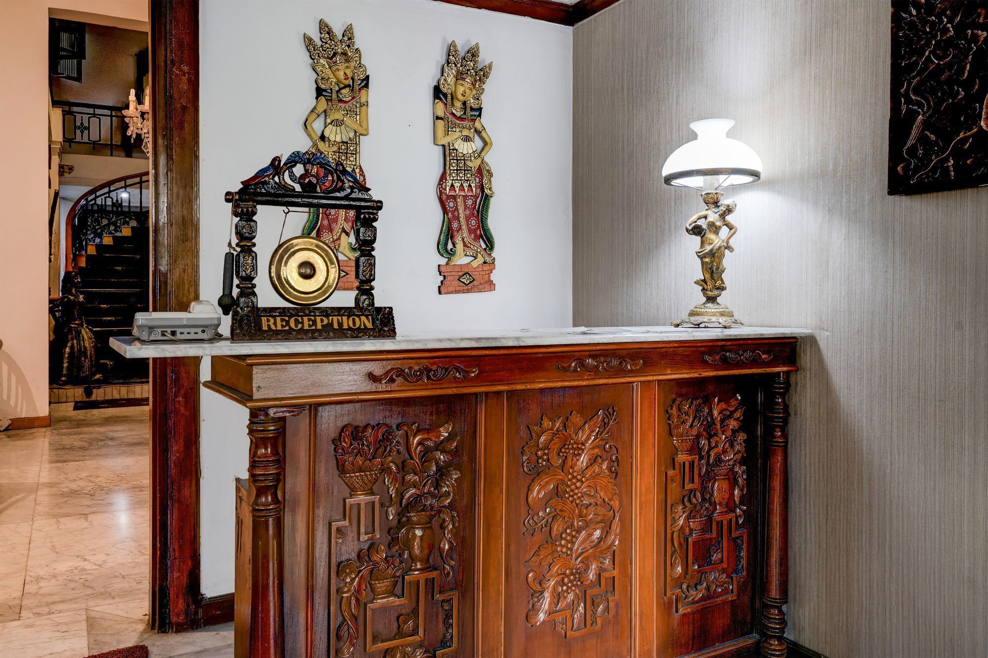 A reception desk with a sign, a clock, and a lamp.
