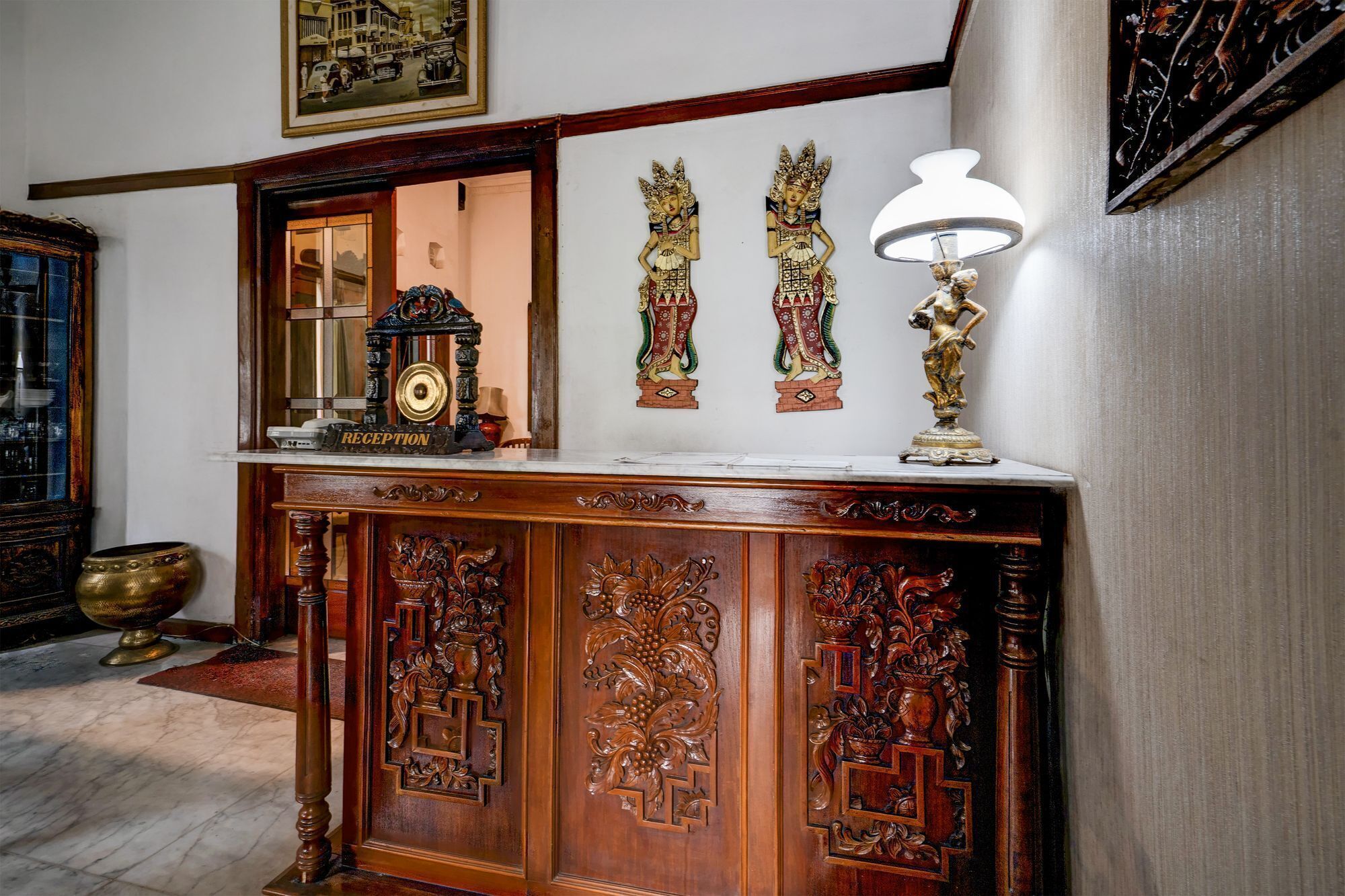 Un mostrador de recepción con un reloj, obras de arte enmarcadas y elementos decorativos.