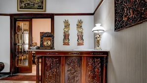 A reception desk with a clock, a lamp, and two wall-mounted decorative pieces.