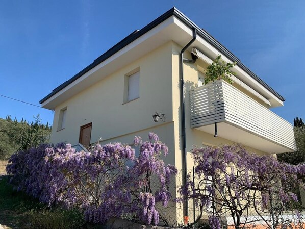 A two-story building with a light-colored facade, a visible window, and a door. - Domus Garda Relax (Garda)