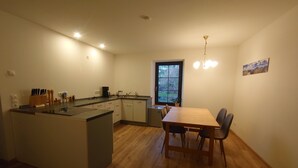 Cocina compacta con comedor, piso de madera y ventana con vistas.
