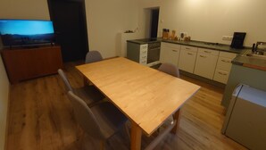 Cocina compacta con comedor, mesa de madera y sillas.