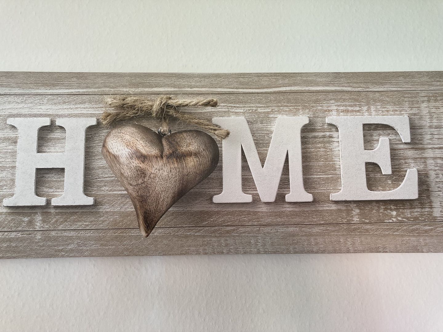 A wooden sign with the word "HOME" and a heart-shaped decoration.