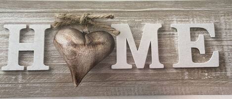A wooden sign with the word "HOME" and a heart-shaped decoration.