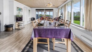 Un comedor amplio con una gran mesa, sillas de madera y vistas al exterior.