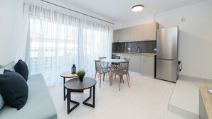 Une cuisine moderne équipée d’un réfrigérateur, de meubles en bois et d’un coin repas avec une table et des chaises.