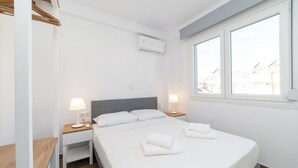 Et moderne hotelværelse med en stor seng, to sengeborde, et vindue med udsigt og en aircondition.