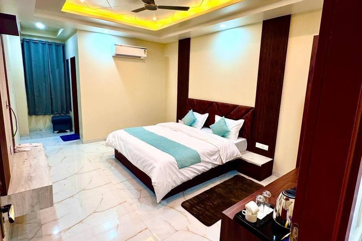 A modern hotel room with a large bed, a ceiling fan, and a marble floor.