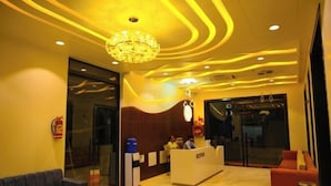 A hotel reception area with a modern design, featuring a reception desk, seating area, and a chandelier. - Hotel Dinanath (Danta Ramgarh)