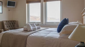 A hotel room with a bed, a chair, a TV, and two windows with blinds. - solas Alainn by Interhome (North Skye)