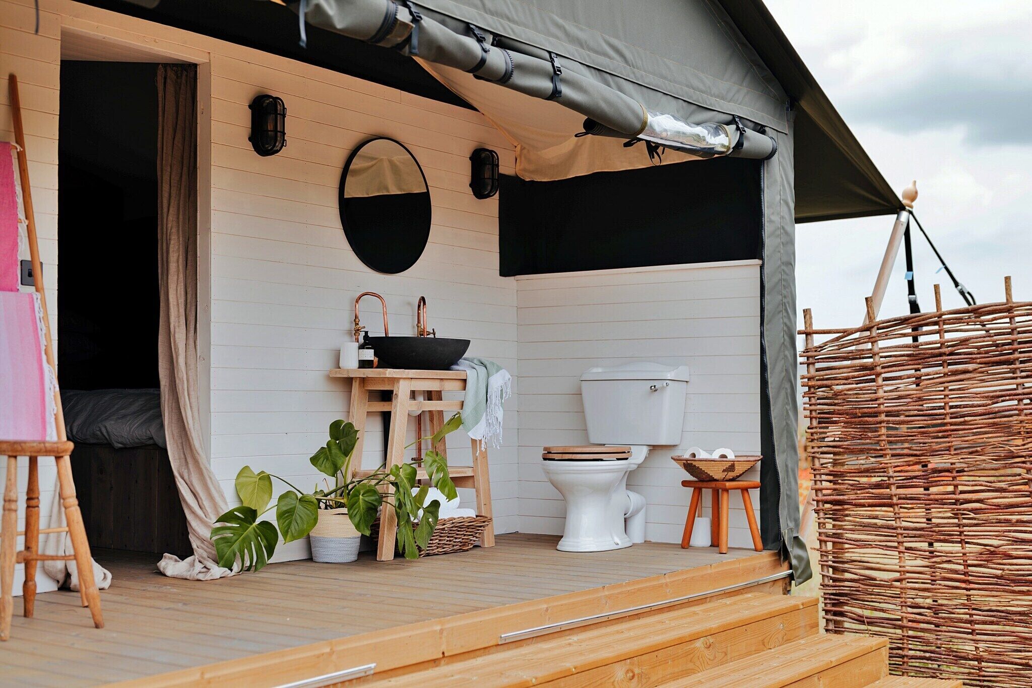 A compact, well-lit wooden cabin with a single bathroom featuring a toilet and sink.
