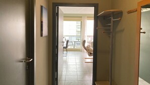 Een gang die uitkomt op een balkon met een eethoek en zitplaatsen.