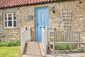 Charming entrance with a traditional picket fence and a cozy bench.