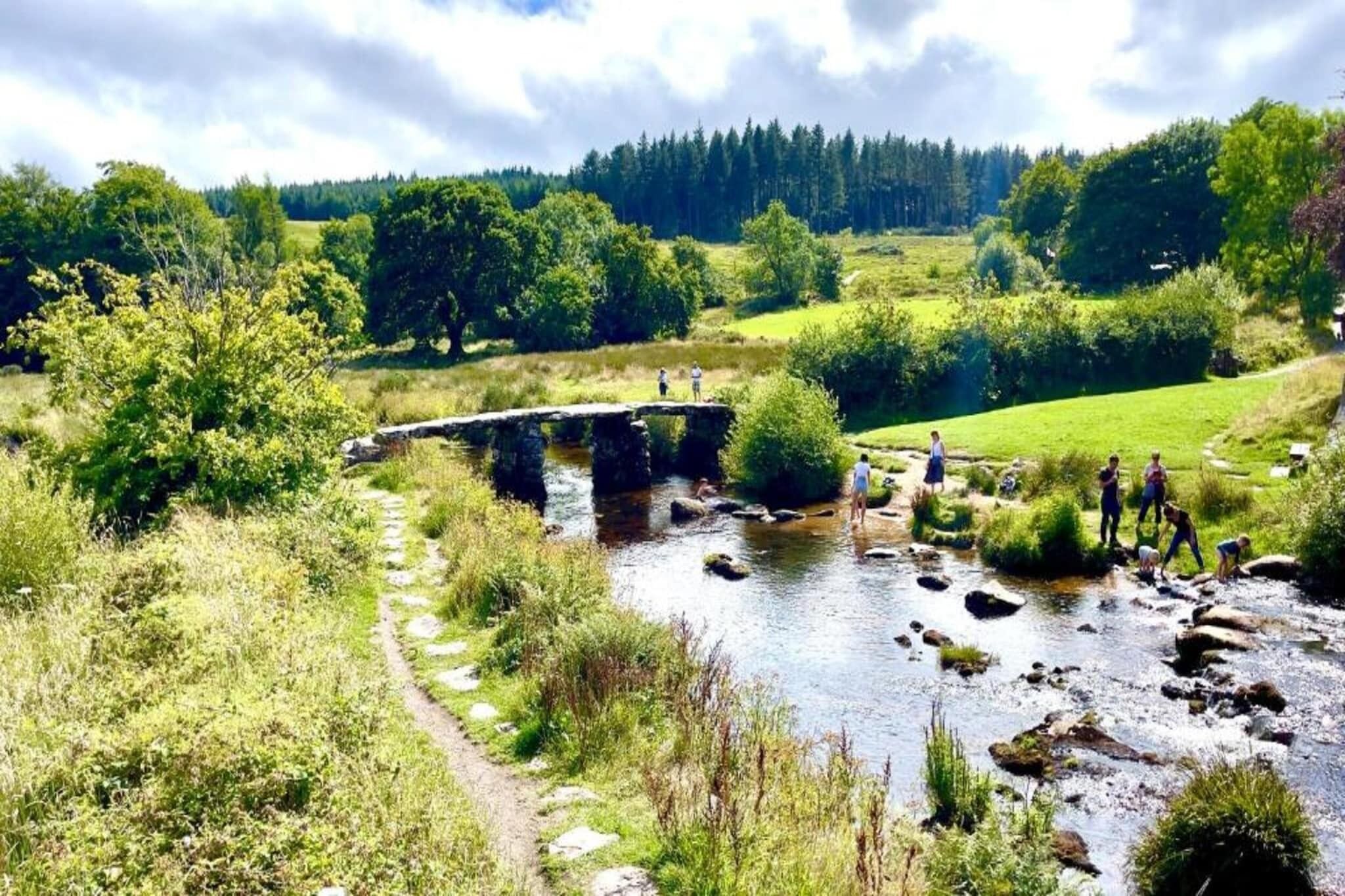 Eine Steinbrücke über einem Fluss, mit Personen, die darauf laufen und sich aufhalten.