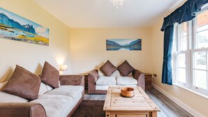 A living room with two sofas, a coffee table, and a painting on the wall. - Cottage in Shropshire near Scenic Trails (Dorrington)