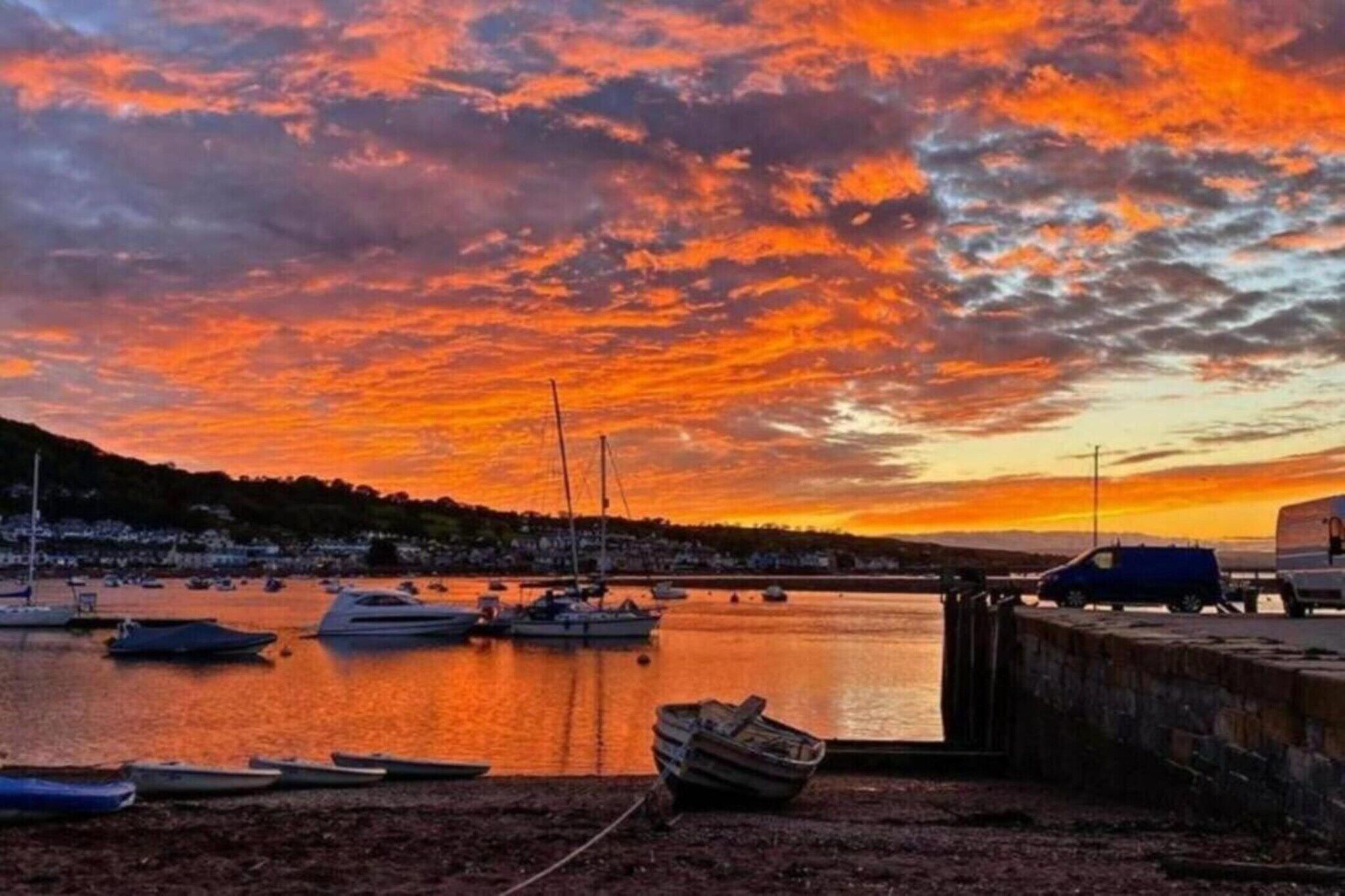 A harbor with boats and a sunset.