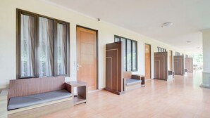 A hallway with seating areas, wooden doors, and large windows. - Hotel O Bogor near Taman Safari formerly Ken Raudhah Inn (Cisarua)